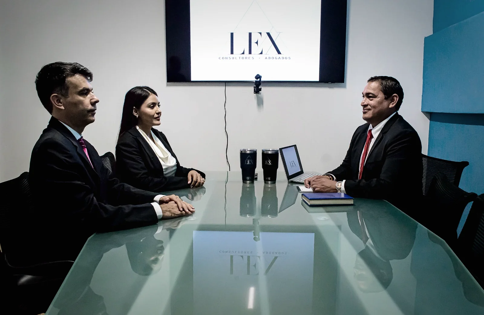 Reunión de atención personalizada entre socios de LEX Consultores y un cliente en sala de juntas